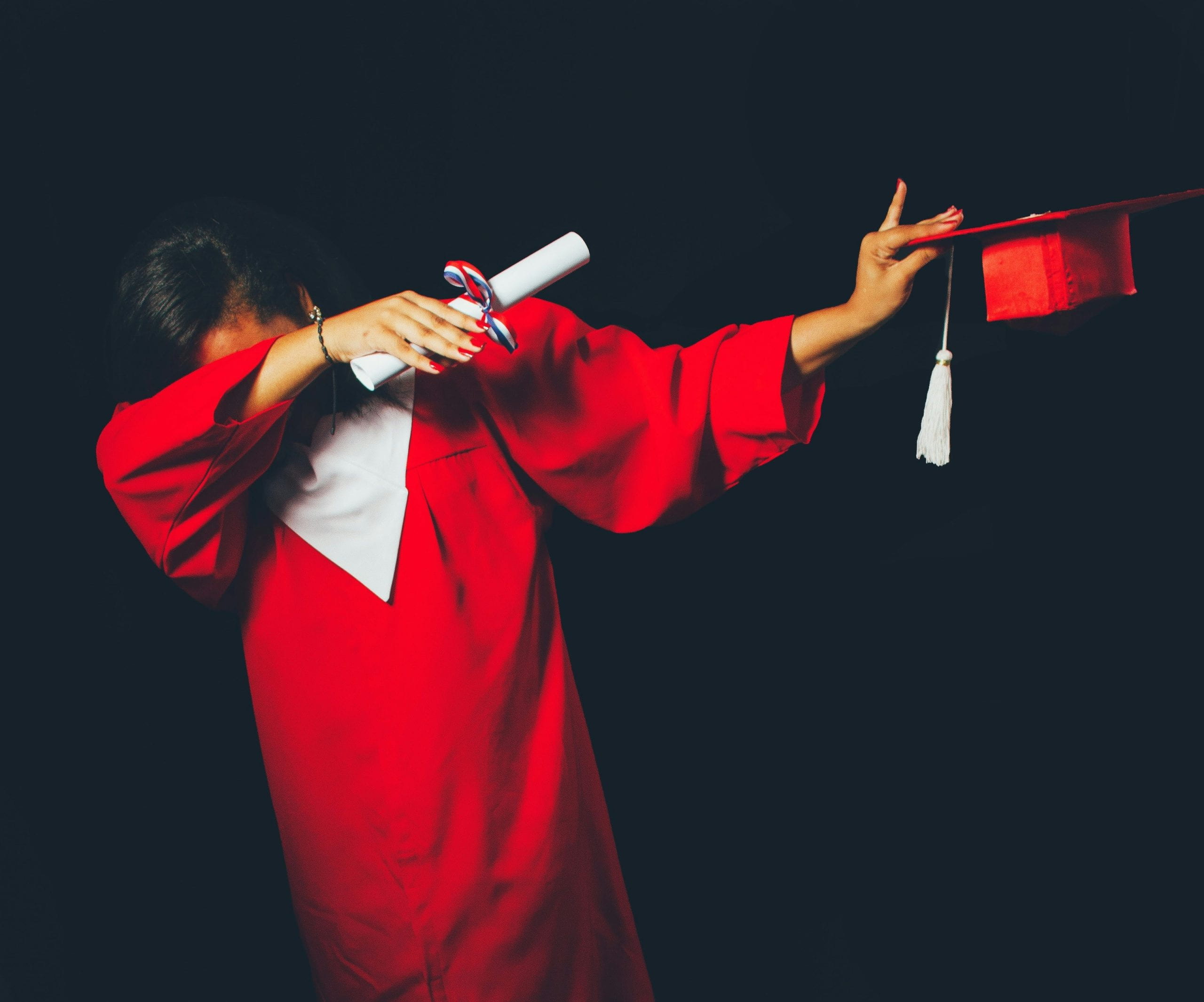 college graduate in gown dabbing
